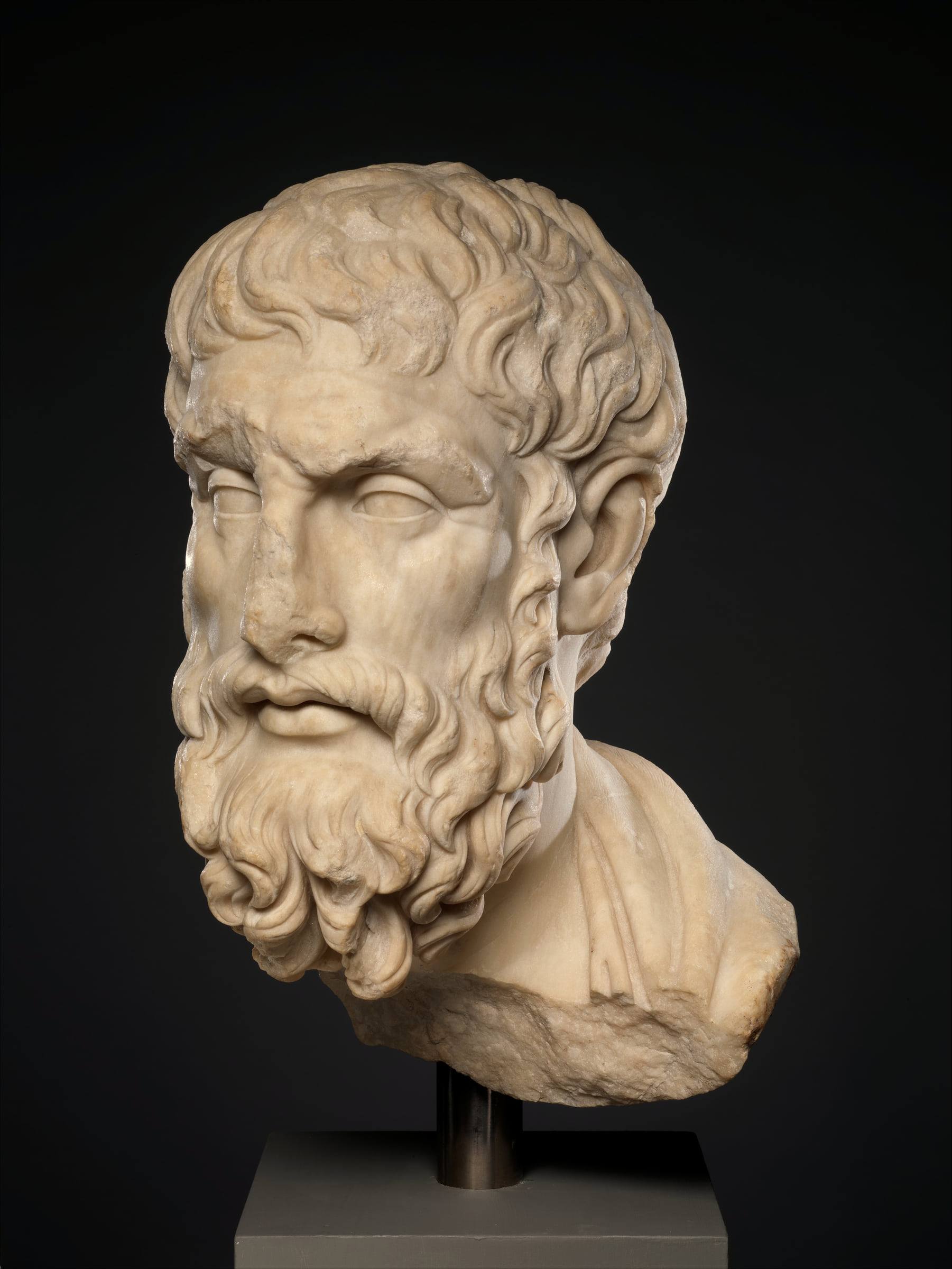Marmorkopf des Philosophen Epikur mit Bart vor dunklem Hintergrund